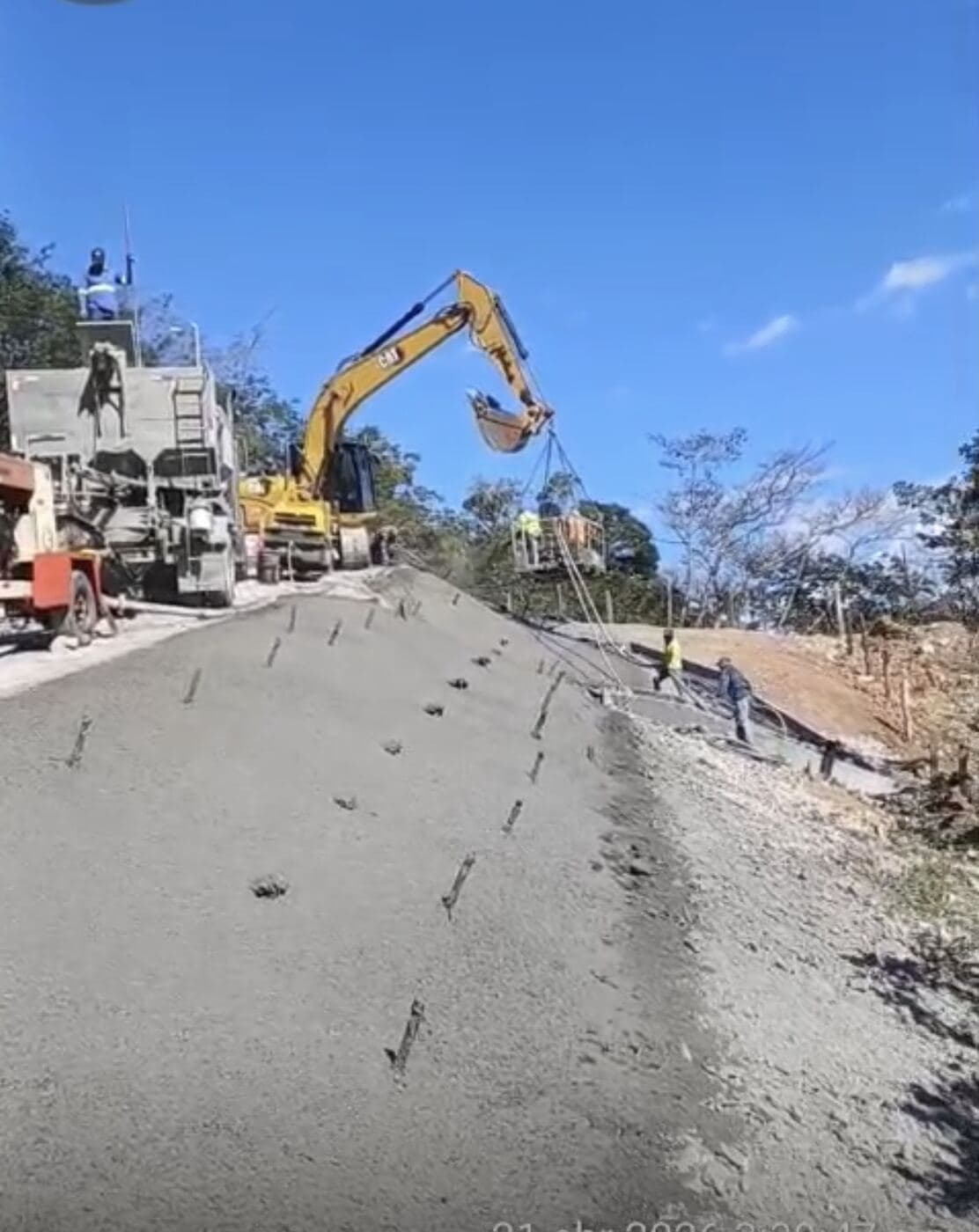 Aplicación de shotcrete sobre el talud con bomba y excavadora con plataforma suspendida