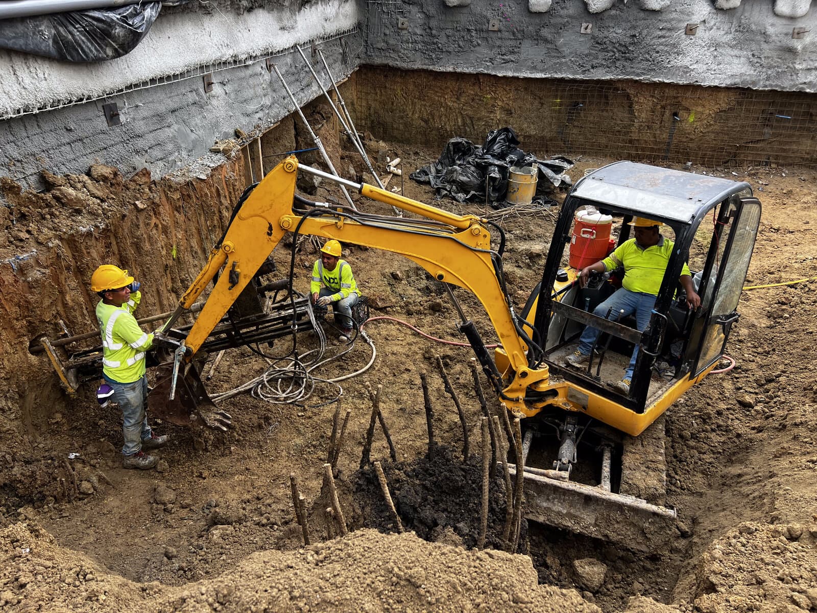 Vista elevada de la excavación con muro de shotcrete, malla y equipo de NDC Geotecnia perforando para las barras de soil nailing, proyecto MANTRA